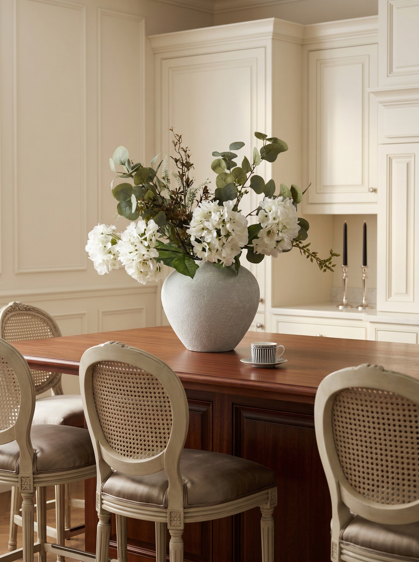 Dining area with a wooden table, chairs, and a vase of flowers.