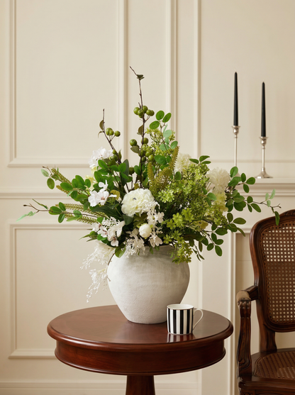 Floral arrangement in a white vase on a wooden table with a neutral background